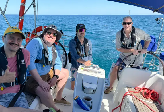 Four men enjoying a day of training on a sailing yacht with the Cruising Yacht Club of South Australia on a sunny day