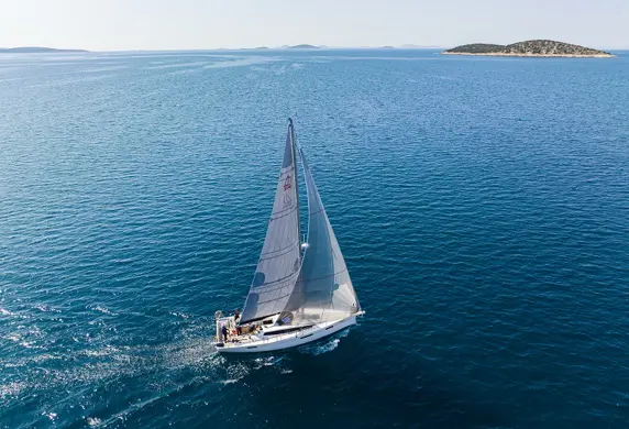Long distance view of a yacht sailing on beautiful blue water from Center of Sailing - Centar Jedrenja, Croatia