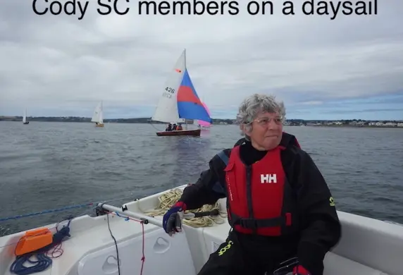 A man on a sailing yacht from Cody Sailing Club on a day sail