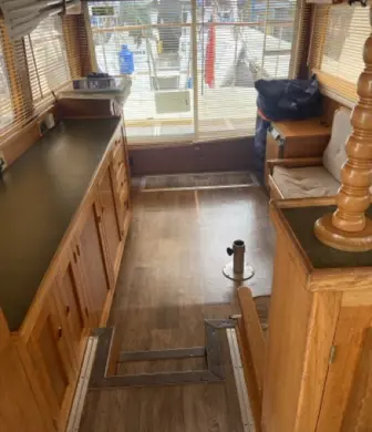 A galley on a cruiser with cupboards on one side looking towards the outside of the boat