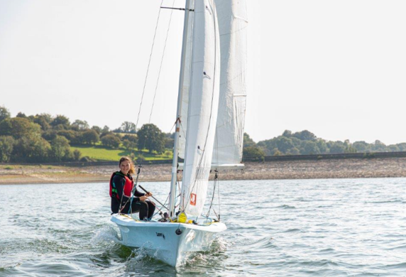 A young girl sailing a dinghy on the reservoir at Llandegfedd Watersports, Pontypool, Gwent