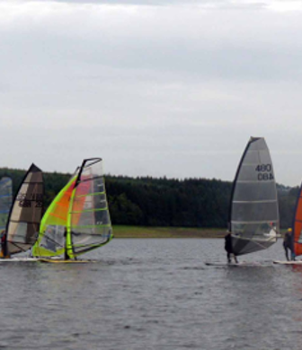 A group of windsurfers on the water at Derwent Reservoir Sailing Club, Consett, County Durham