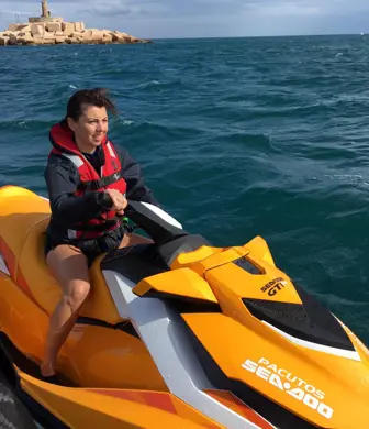 A lady on a yellow jet ski alongside an orange rigid inflatable boat (RIB)