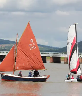 A Siren and catamaran sailing on the water on a cloudy day