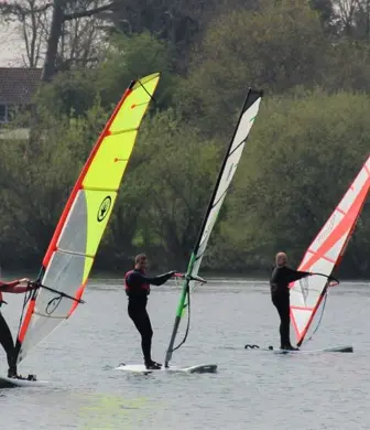 Three people windsurfing on the water