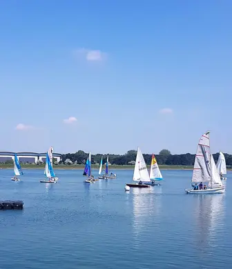 A large group of dinghies and sail boats on a lovely sunny day enjoying sailing on the Grimsbury Reservoir at Banbury Cross Sailing Club