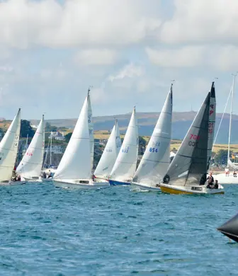 A fleet of Pandora sail boats racing on the water at South Caernarvonshire Yacht Club, Abersoch, Wales