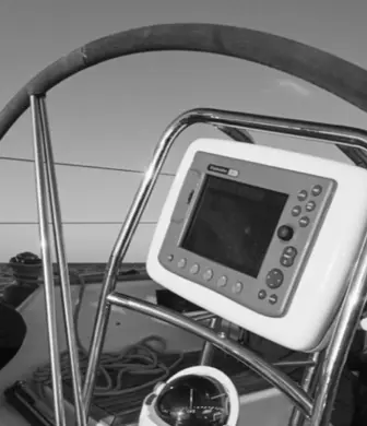 A lady helming a yacht with one hand in black and white