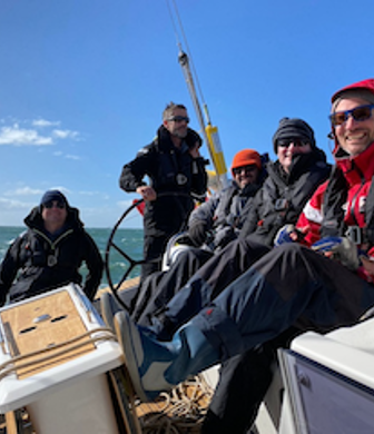 Universal Sailing School group of men enjoying a sail on a sunny day