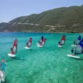 Eight people learning to windsurf on beautiful blue/green water at Watersports Nomad, Vassiliki, Greece