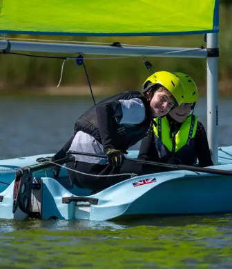 Two young people enjoying sailing a Pico dinghy on the open water