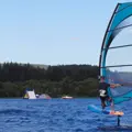 Two people wind foiling on the open water