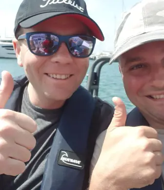 Two smiling men on a RIB with their thumbs up