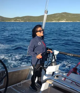 A smiling lady at the helm of a yacht from the Center of Sailing - Centar Jedrenja, Croatia