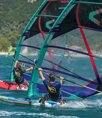 Two people leaning right back on windsurfs blasting across the sea at Watersports Nomad, Vassiliki, Greece