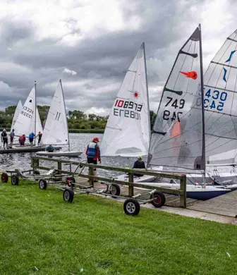 A group of Laser dinghies on the shore waiting to be launched