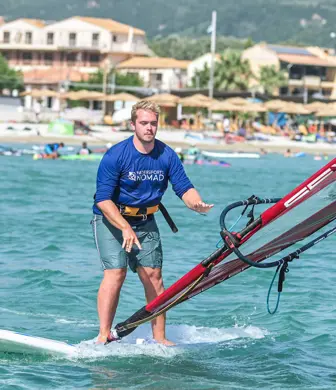 A man learning to windsurf - he's just dropped the sail into the water at Watersports Nomad, Vassiliki, Greece