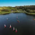 An aerial view of dinghies sailing on the reservoir at Llandegfedd Watersports, Pontypool, Gwent taken by a drone