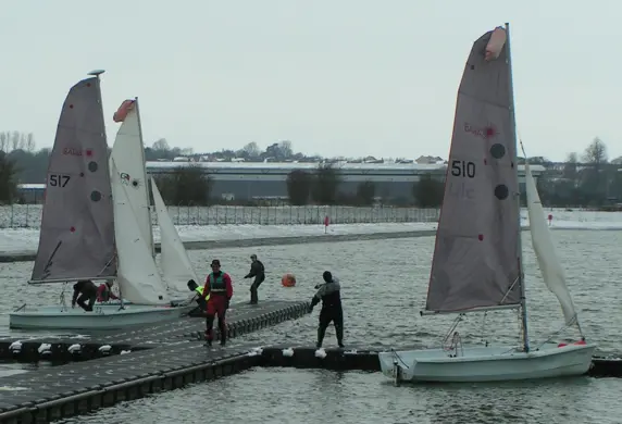 Sail boats preparing to launch from the jetty at Grimsbury Reservoir at Banbury Cross Sailing Club
