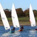 A close up of three small sail boats on the water at Grimsbury Reservoir at Banbury Cross Sailing Club