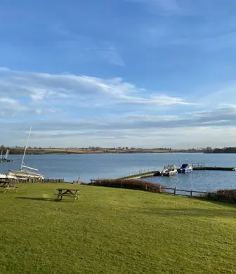 The Pitsford Reservoir with the jetty and boats moored up taken from the shore where the Northampton Sailing Club are based