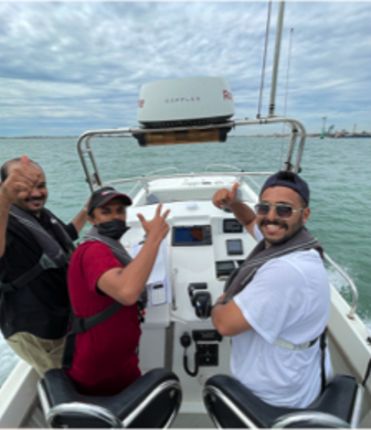 Three happy men enjoying a ride on a rigid inflatable boat (RIB) on the water