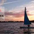 A yacht on the water against a sunset at the Phoenix Canoe Club and Outdoor Centre