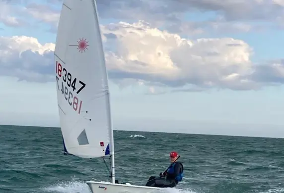 A single Laser dinghy sailing on the open water