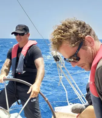 Three people enjoying a day sailing on a sunny day