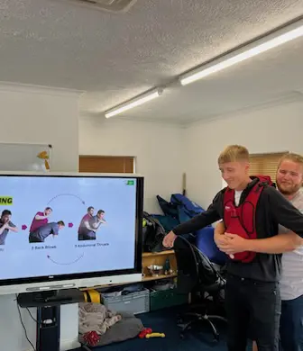An instructor demonstrating choking first aid