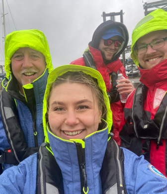 A group of course participants in wet weather gear enjoying their day despite the weather at Ocean Sports Tuition, Southampton
