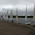 A line of Laser dinghies with their sails up along the jetty 