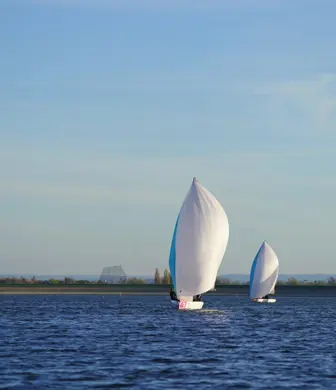 A group of RS21 keelboats sailing with their kites up at Queen Mary Sailing Club, Ashford