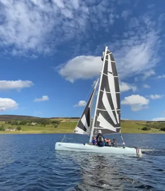 Yacht sailing on Whiteadder Reservoir on a sunny day